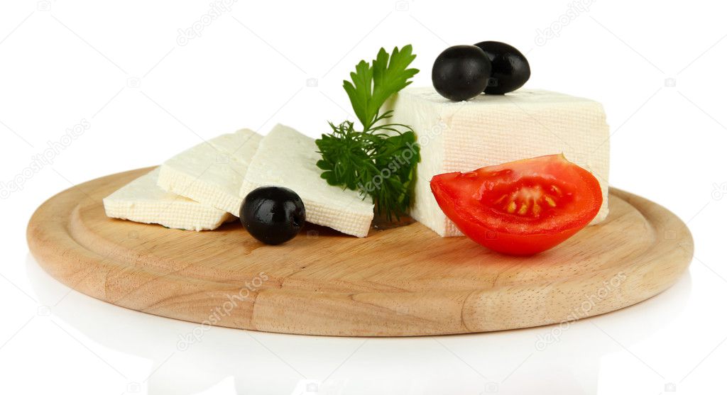 Sheep milk cheese, black olives, red tomato with parsley and dill on cutting board, isolated on white