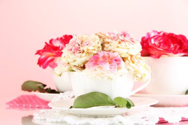 gül pembe bir arka plan üzerinde peçete üzerinde bardak