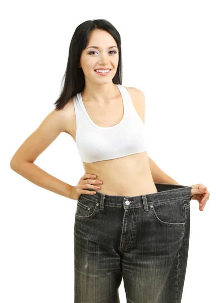 Belle jeune femme avec de gros jeans isolés sur blanc — Photo