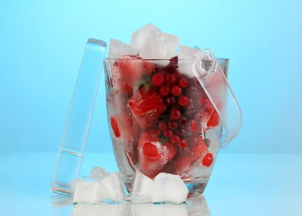 Frozen berries in bucket of ice on color background — Stock Photo, Image