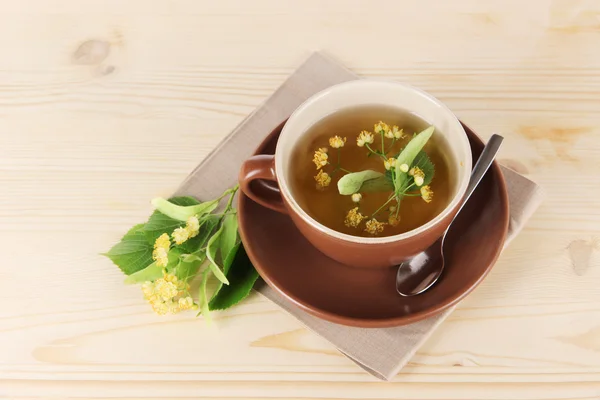 Kopje thee met linden op servet houten tafel — Stockfoto