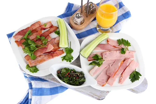 Bacon on plates on napkin on board isolated on white — Stock Photo, Image