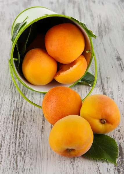 Apricots in bucket on wooden table — Stock Photo, Image