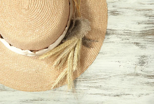 Beautiful summer hat with spikelets on wooden background — Stockfoto