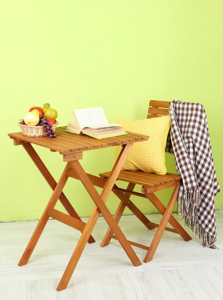 Träbord med frukt och bok om det i rummet — Stockfoto