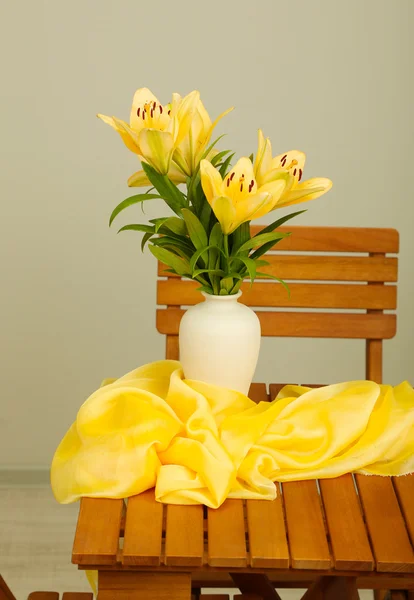 Beautiful orange lilies in vase on wooden table — Stock Photo, Image