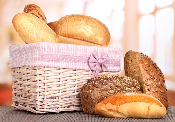 Brot gebacken in Weidenkorb auf Fensterhintergrund — Stockfoto