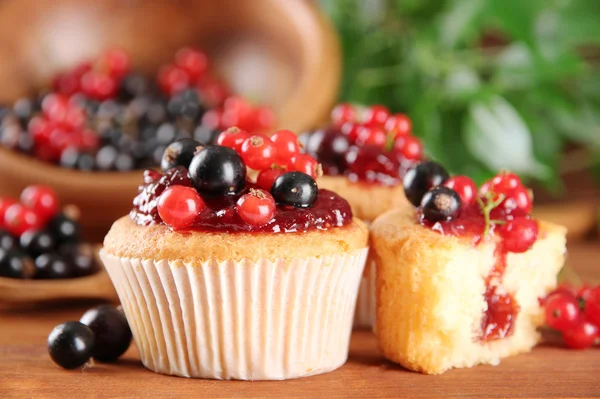 Smakelijke muffins met bessen op houten tafel — Stockfoto