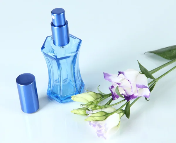 Άρωμα σε μπουκάλι και λουλούδια που απομονώνονται σε λευκό — Φωτογραφία Αρχείου