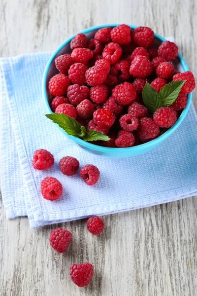 Ripe sweet raspberries in bowl on wooden background — Stock Photo, Image