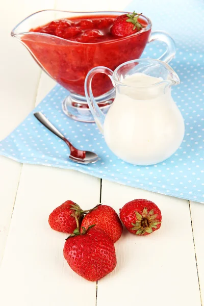 Homemade strawberry jam, on napkin, on color wooden background — Stock Photo, Image