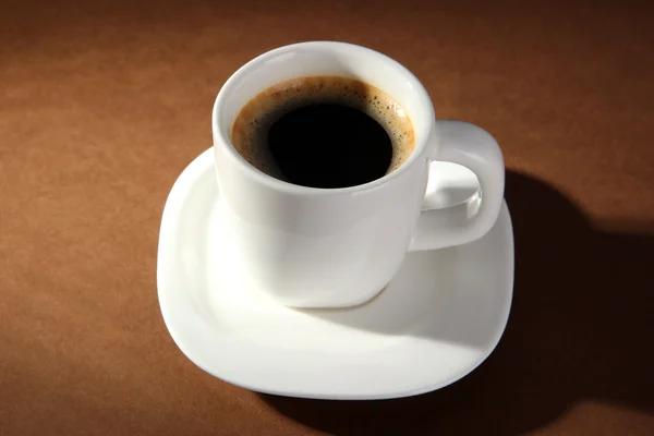 Tasse Kaffee auf braunem Hintergrund — Stockfoto