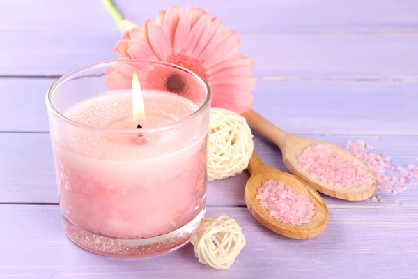 Hermosa vela rosa con flor sobre fondo de madera púrpura — Foto de Stock