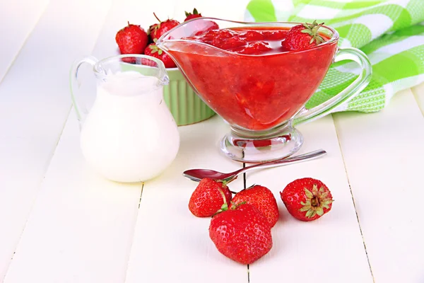 Homemade strawberry jam, on napkin, on color wooden background — Stock Photo, Image