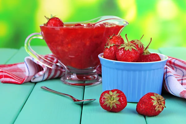 Homemade strawberry jam, on napkin, on color wooden table, on bright background — Stock Photo, Image