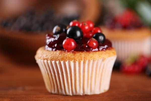 Leckeres Muffin mit Beeren auf Holztisch — Stockfoto