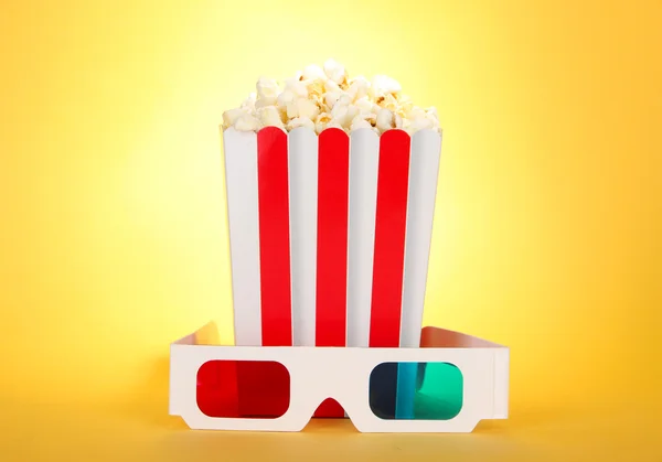 Palomitas de maíz y gafas 3D sobre fondo amarillo — Foto de Stock