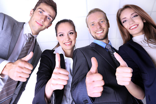 Business team showing thumbs up in office