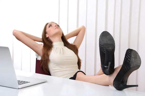 Ayakkabılarını tablo ile onun ofisinde istirahat iş kadını — Stok fotoğraf