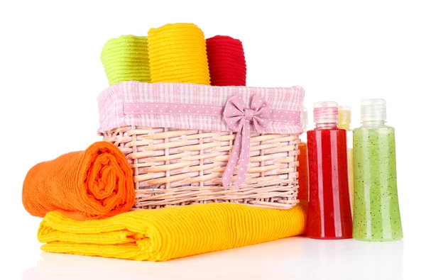Asciugamani colorati in cestino e bottiglie di cosmetici, isolati su bianco — Foto Stock
