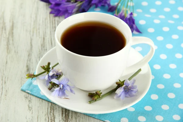 Xícara de chá com chicória, em fundo de madeira — Fotografia de Stock