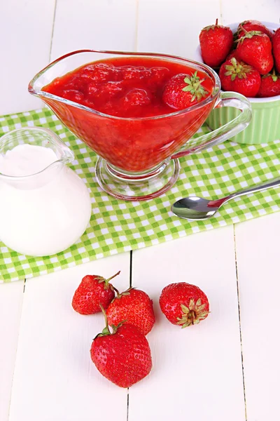 Homemade strawberry jam, on napkin, on color wooden background — Stock Photo, Image