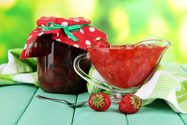 Homemade strawberry jam, on napkin, on color wooden table, on bright background — Stock Photo, Image