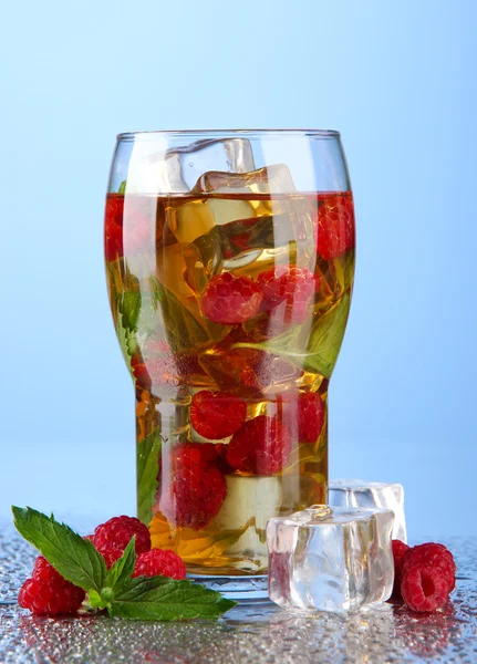 Iced tea with raspberries and mint on blue background — Stock Photo, Image