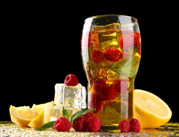 Iced tea with raspberries and mint on dark background with yellow light — Stock Photo, Image