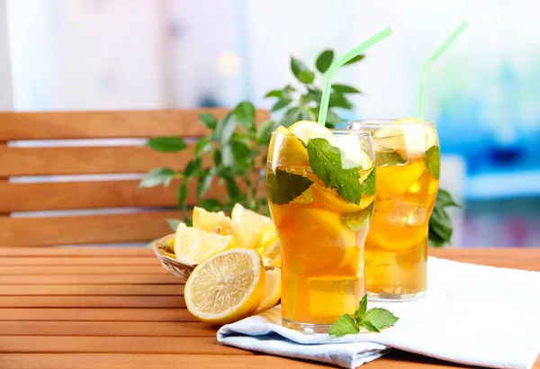 Ijsthee met citroen en mint op houten tafel, buitenshuis — Stockfoto