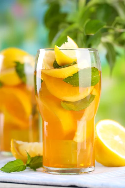 Tè freddo con limone e menta sul tavolo di legno, all'aperto — Foto Stock