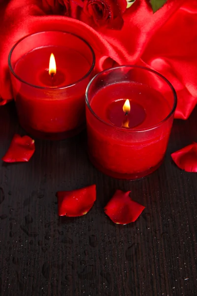 Linda vela vermelha romântica com flores, close-up — Fotografia de Stock