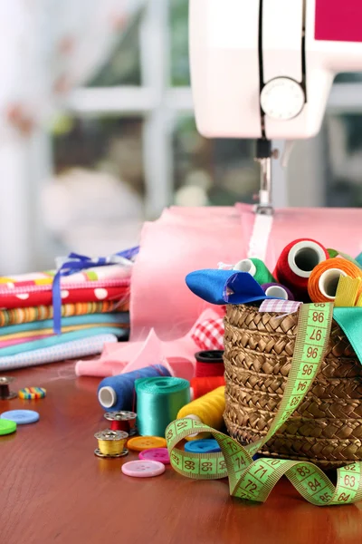 Máquina de coser y tela sobre fondo brillante —  Fotos de Stock