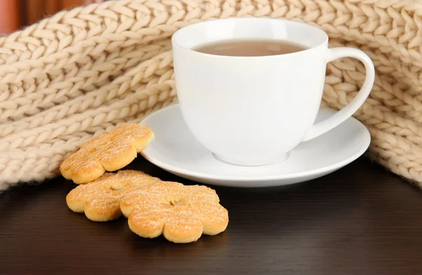 Cup of tea with scarf on table in room — Stock Photo, Image