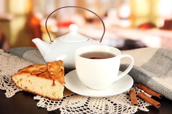 Tasse de thé avec écharpe sur la table dans la chambre — Photo