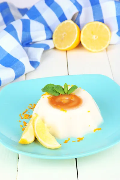 Citroen panna cotta met oranje schil en karamel saus, op een houten achtergrond kleur — Stockfoto