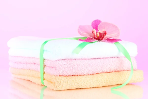 Handdoeken gebonden met lint op lichte roze achtergrond — Stockfoto