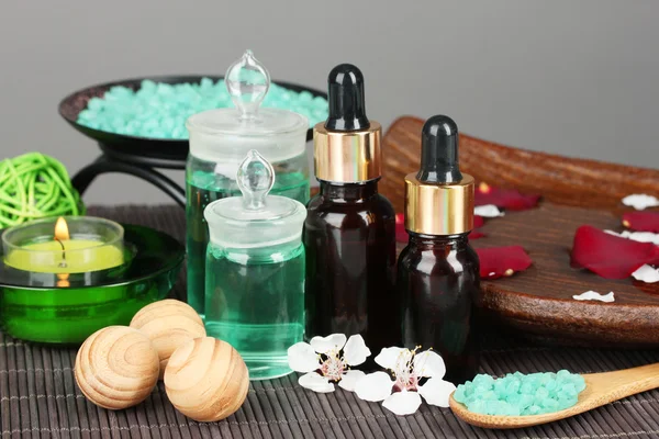 Spa kompozycja z olejkami aromatycznymi na stole na szarym tle — Zdjęcie stockowe