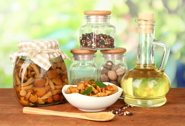 Složení vynikající marinované houby, oleje a koření na dřevěný stůl na světlé pozadí — Stock fotografie