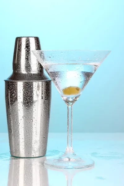 Shaker and cocktail on blue background — Stock Photo, Image