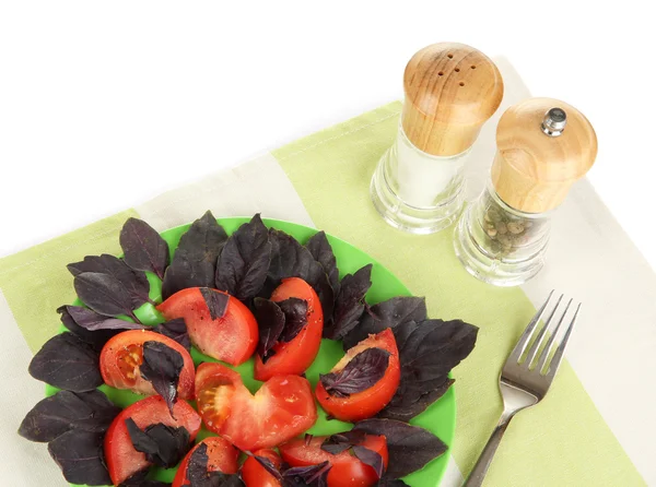 Салат из свежих помидоров с листьями базилика на салфетке изолированы на белом — стоковое фото