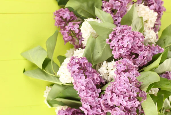 Beautiful lilac flowers, on color wooden background — Stock Photo, Image