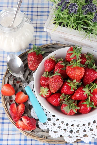 Aardbeien in plaat op rieten staan op servet — Stockfoto