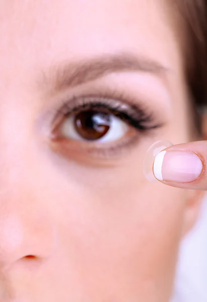 Młoda kobieta wprowadzenie soczewek kontaktowych w oku z bliska — Zdjęcie stockowe