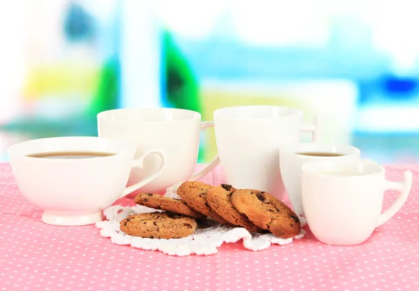 ウィンドウの背景にピンクのナプキンにクッキーとコーヒーのカップ — ストック写真