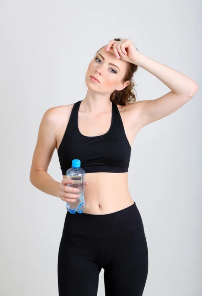 Beautiful young woman with bottle of water — Stock Photo, Image