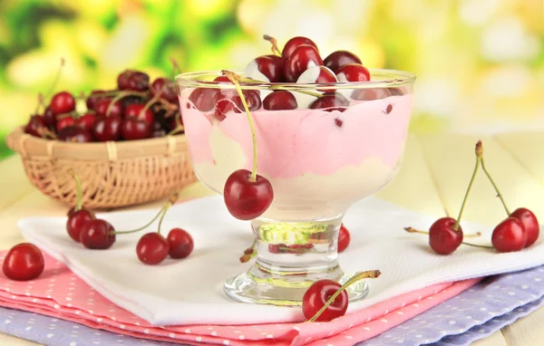 Delizioso dessert di ciliegie in vaso di vetro su tavolo di legno su sfondo naturale — Foto Stock