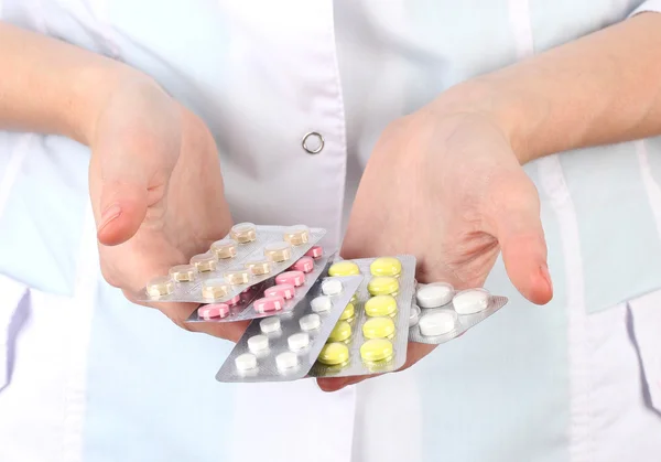 Primer plano de las píldoras de la mano del médico femenino, aisladas en blanco —  Fotos de Stock