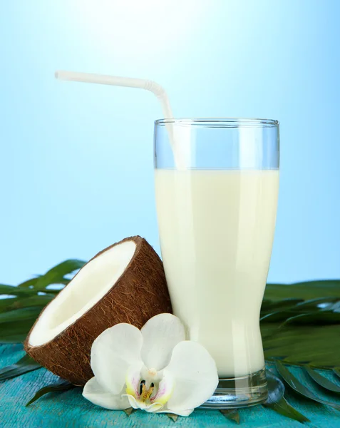 Kokosnuss mit Glas Milch, auf blauem Hintergrund — Stockfoto