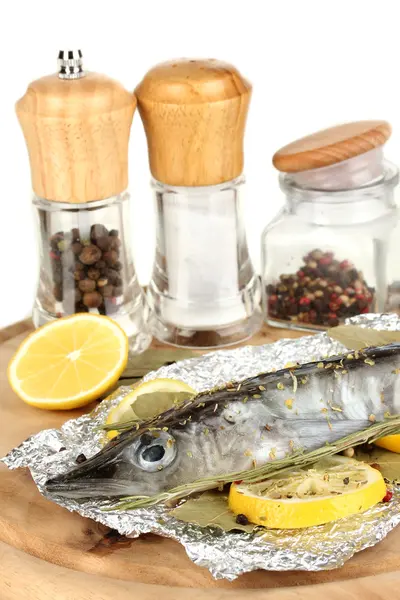 Fish in foil with herbs and lemon on board isolated on white — Stock Photo, Image